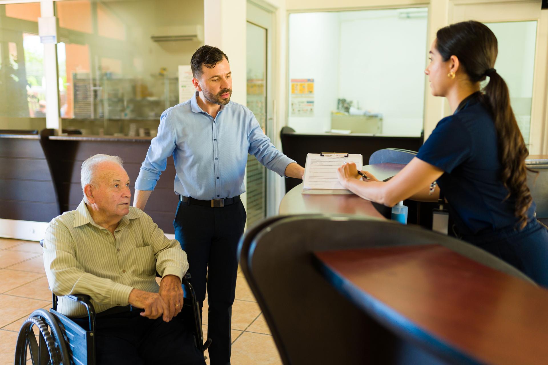 Retired elderly man at the nursing home filing a registration form